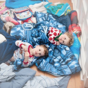 Children playing in a colorful mess of blankets